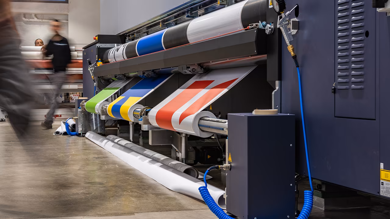 Large-format printing equipment producing colorful banners at Cal Poly Print & Copy.